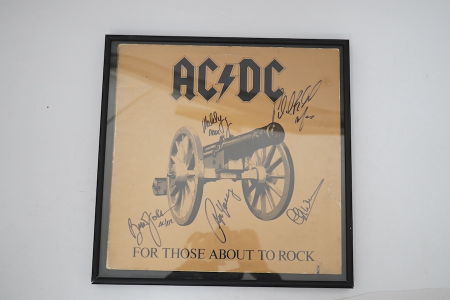 A signed AC/DC album with five autographs of; Angus Young, Phil Rudd, Cliff Williams, Brian Johnson and Malcolm Young, all signed in black felt tip on the cover of the album ‘For Those About To Rock’, framed. Condition -